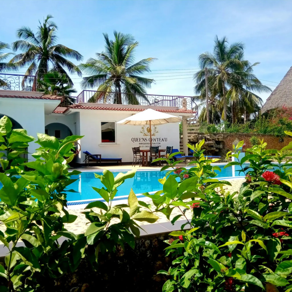 Resort pool among palm trees on the coast